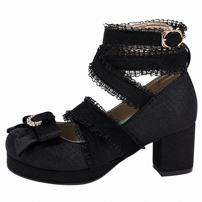 A black platform block heel shoe with lace-up ankle straps, a bow on the toe, and a rhinestone-embellished buckle, shown against a plain white background.