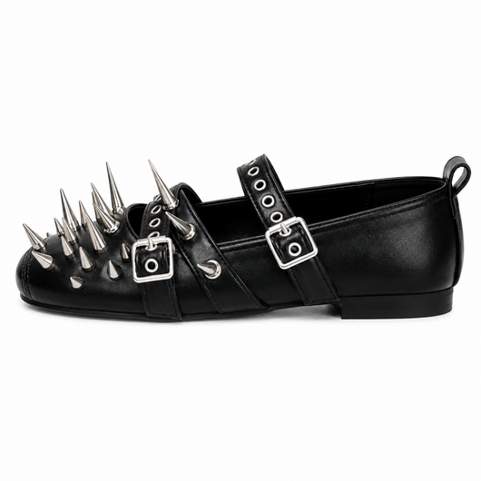 A black leather flat shoe decorated with multiple silver metal spikes on the toe and silver buckles on the straps, shown against a plain white background.